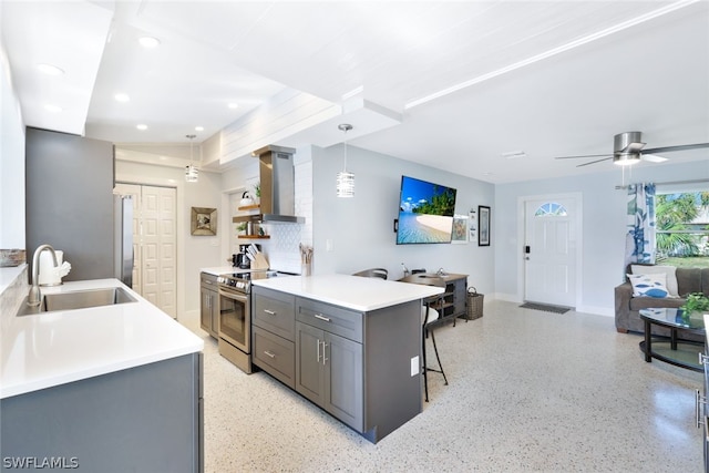 kitchen with hanging light fixtures, sink, gray cabinets, wall chimney exhaust hood, and stainless steel appliances