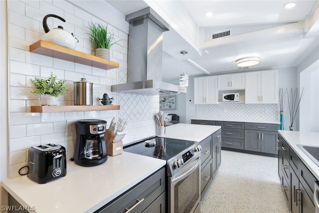 kitchen with gray cabinetry, tasteful backsplash, island range hood, stainless steel range with electric stovetop, and hanging light fixtures