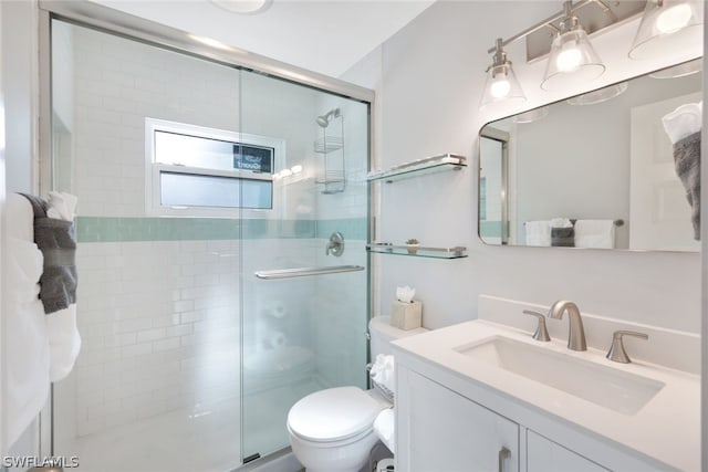 bathroom with vanity, a shower with shower door, and toilet