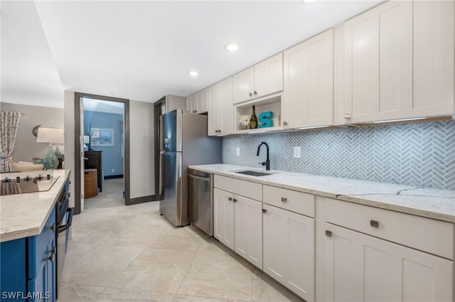 kitchen featuring white cabinets, light tile flooring, stainless steel appliances, sink, and tasteful backsplash