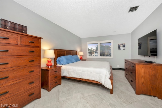 tiled bedroom featuring a textured ceiling