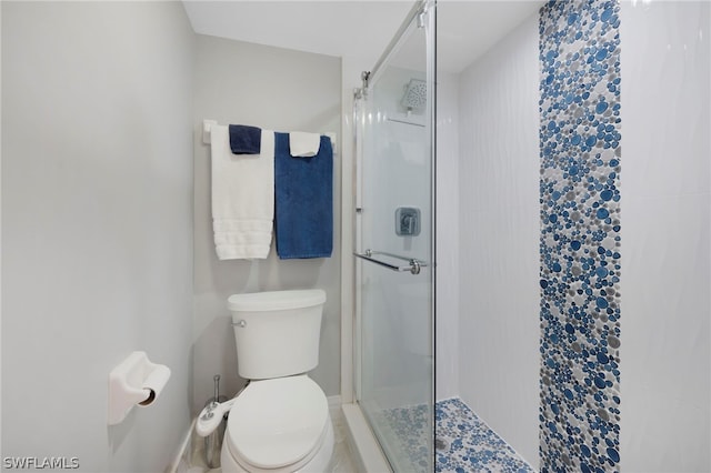 bathroom with a shower with shower door and toilet