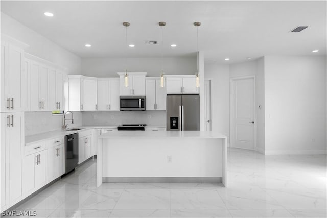 kitchen featuring white cabinets, a kitchen island, decorative light fixtures, and appliances with stainless steel finishes