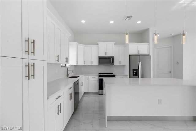 kitchen with a center island, white cabinets, sink, hanging light fixtures, and stainless steel appliances