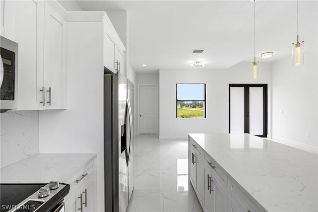 kitchen featuring white cabinets, decorative light fixtures, light stone counters, and appliances with stainless steel finishes