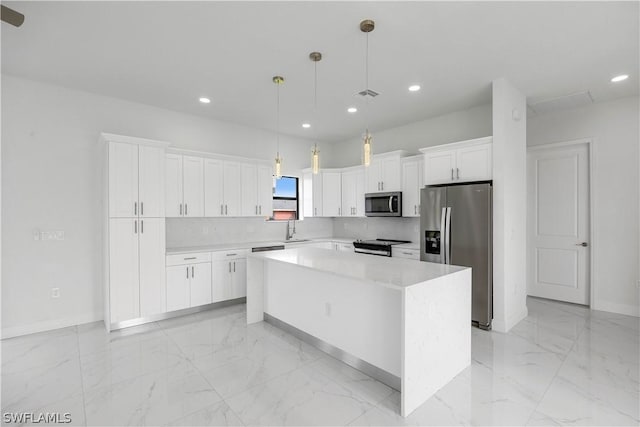 kitchen featuring white cabinetry, sink, a center island, hanging light fixtures, and appliances with stainless steel finishes