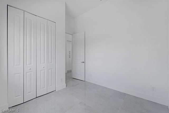 unfurnished bedroom with a closet and light tile floors