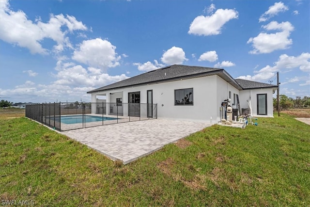 back of property with a patio area, a lawn, and a fenced in pool