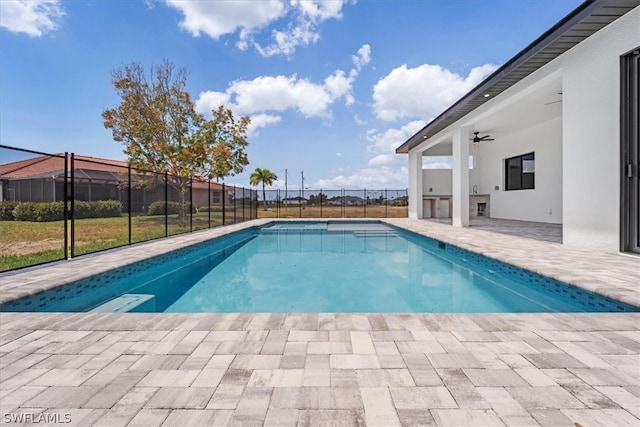 view of swimming pool with ceiling fan and a patio