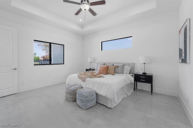 tiled bedroom with ceiling fan and a raised ceiling