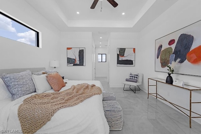 bedroom featuring light tile flooring, ceiling fan, and a tray ceiling