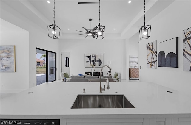 kitchen with a raised ceiling, pendant lighting, and sink