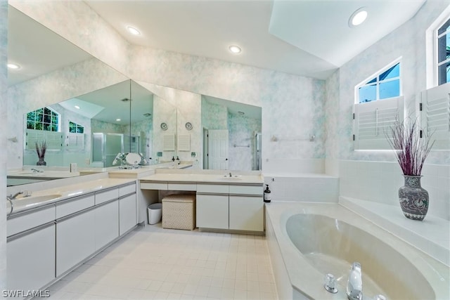 bathroom with a tub to relax in, tile patterned floors, vanity, and vaulted ceiling