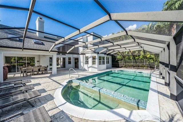 view of pool with glass enclosure and a patio