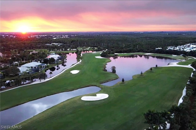 aerial view at dusk featuring a water view