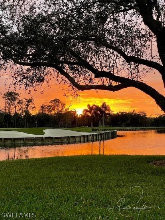 surrounding community with a lawn and a water view