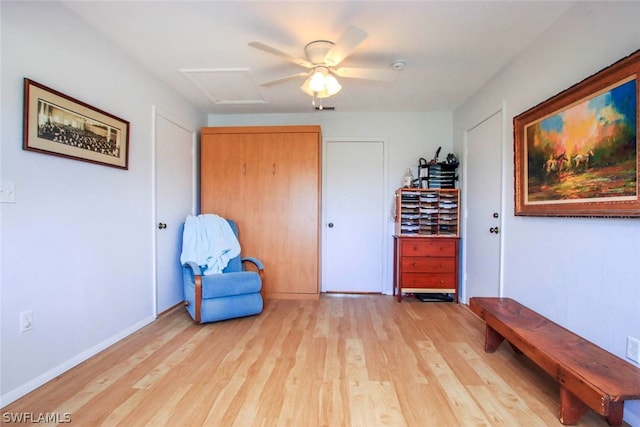 sitting room featuring wood-type flooring and ceiling fan