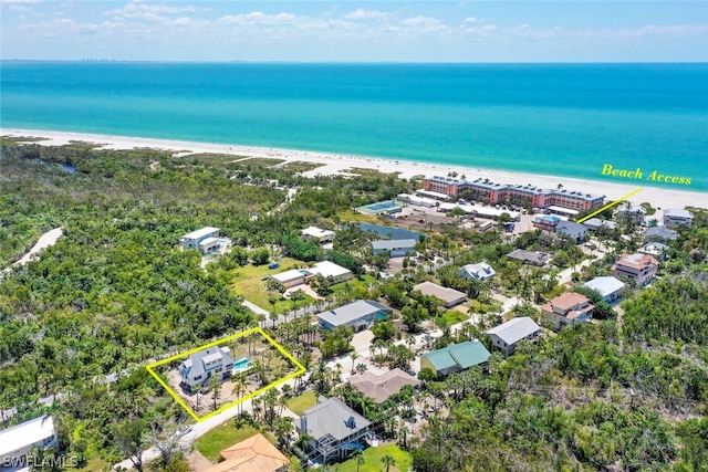 birds eye view of property featuring a water view and a beach view