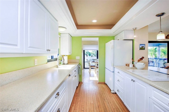 kitchen featuring plenty of natural light, light wood-type flooring, pendant lighting, and white cabinetry