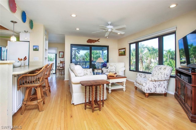 living room with ceiling fan and light wood-type flooring