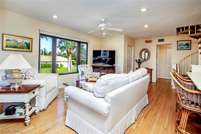 living room featuring ceiling fan and light wood-type flooring