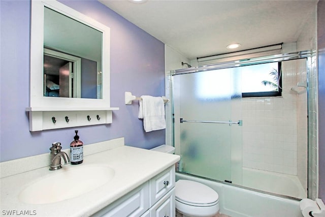 full bathroom with vanity, toilet, and shower / bath combination with glass door