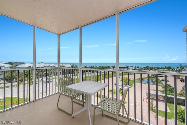 sunroom / solarium featuring a water view