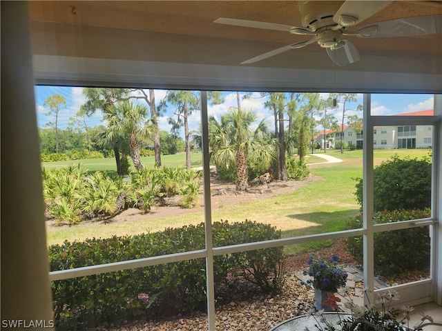 unfurnished sunroom featuring ceiling fan and a wealth of natural light