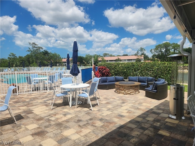 view of terrace with an outdoor living space with a fire pit and a community pool