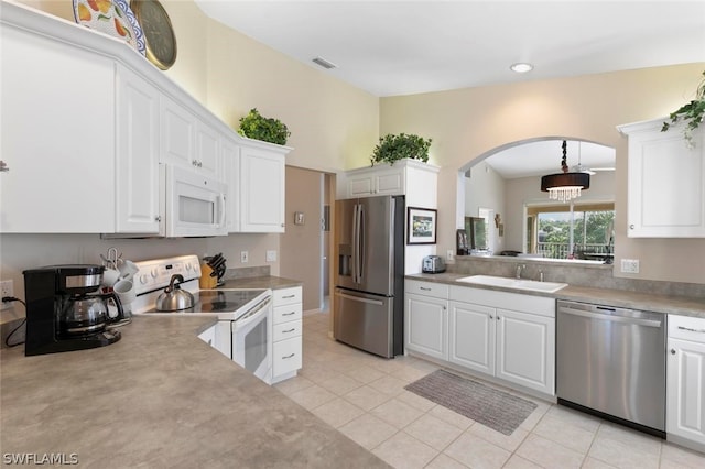 kitchen with white cabinetry, stainless steel appliances, decorative light fixtures, sink, and light tile patterned flooring