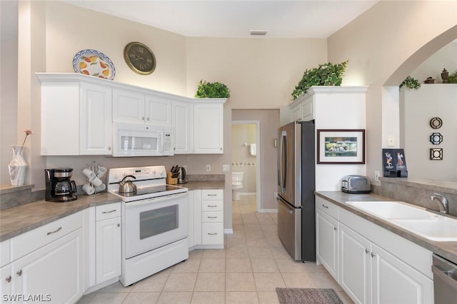 kitchen featuring light tile patterned flooring, white cabinetry, stainless steel appliances, and sink