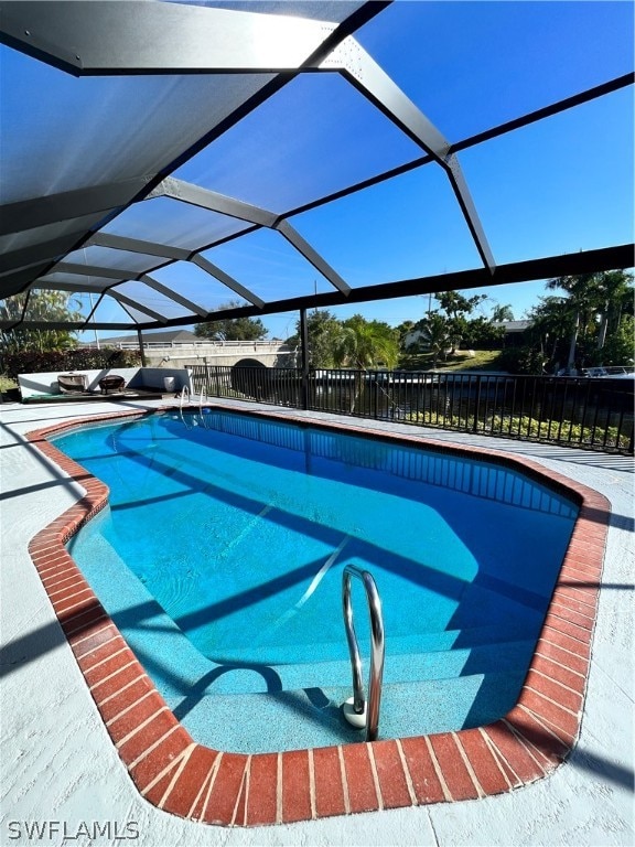 view of swimming pool featuring glass enclosure