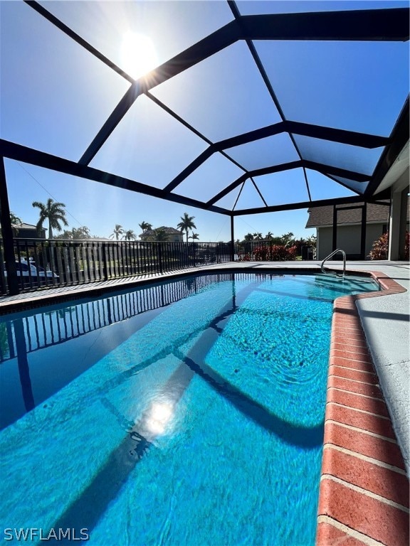 view of swimming pool featuring a lanai