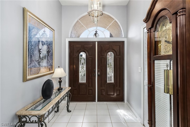 entryway featuring an inviting chandelier, light tile patterned floors, a high ceiling, and french doors