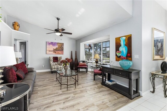 living room with ceiling fan, light wood-type flooring, and vaulted ceiling