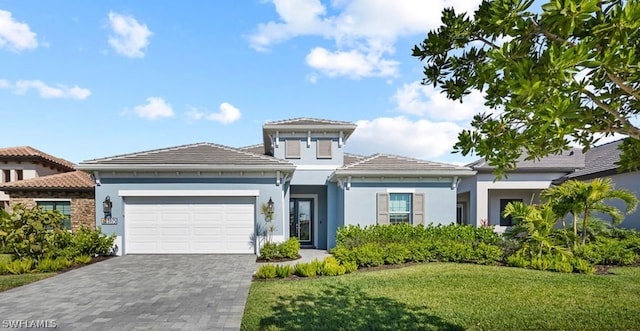 mediterranean / spanish home with a front lawn and a garage