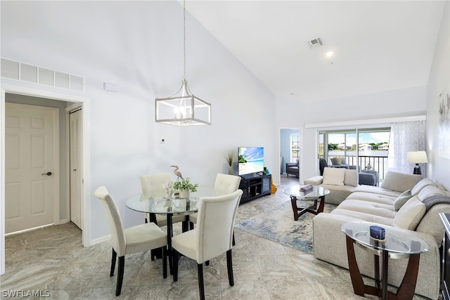 dining space featuring high vaulted ceiling, light tile flooring, and a chandelier