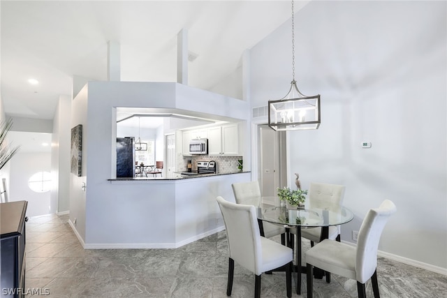 tiled dining area with a notable chandelier and a high ceiling