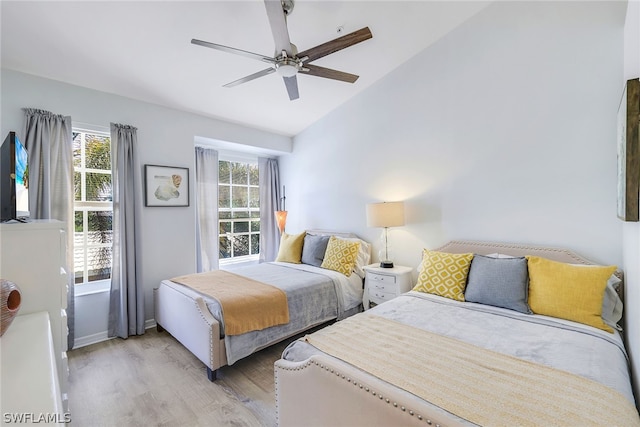 bedroom featuring ceiling fan, vaulted ceiling, and light hardwood / wood-style floors