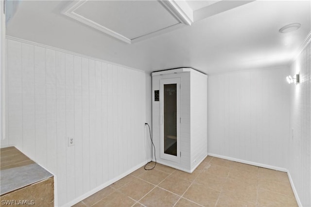 unfurnished room featuring wood walls and light tile patterned floors