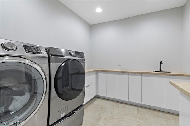 laundry area featuring cabinets, sink, and washing machine and clothes dryer