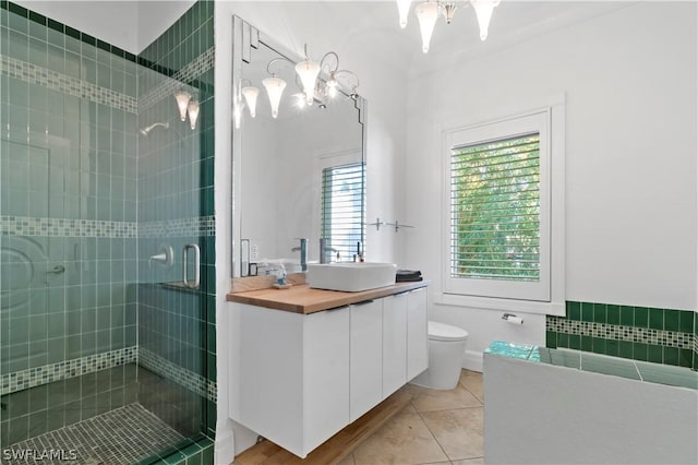 bathroom with tile patterned flooring, vanity, toilet, and a shower with shower door