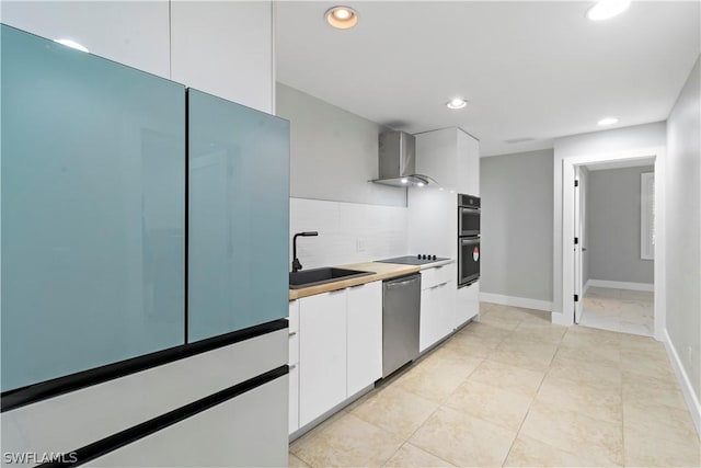 kitchen with sink, wall chimney exhaust hood, stainless steel appliances, tasteful backsplash, and white cabinets