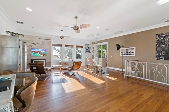 living room with wood-type flooring, ceiling fan, and ornamental molding