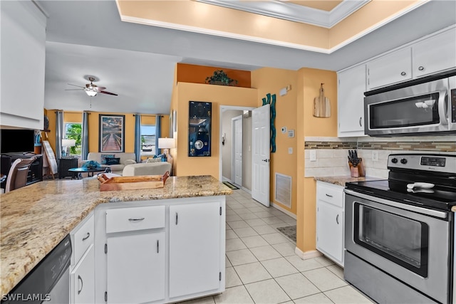 kitchen with ceiling fan, stainless steel appliances, backsplash, and white cabinets