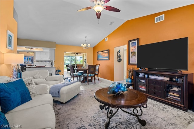 living room with ceiling fan with notable chandelier, vaulted ceiling, and light tile patterned floors