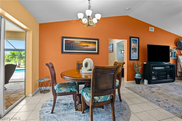 tiled dining space featuring lofted ceiling and a chandelier