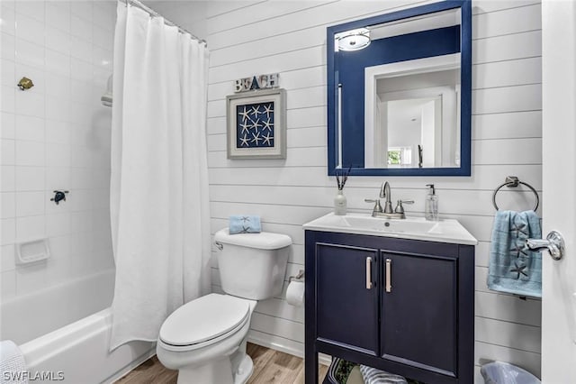 full bathroom featuring shower / tub combo with curtain, wood-type flooring, vanity, and toilet