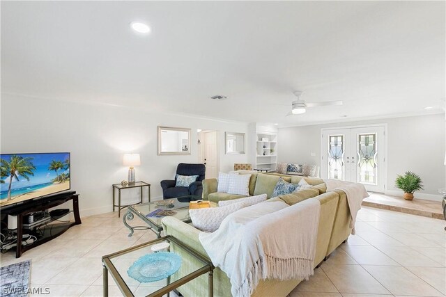 tiled living room with ceiling fan and french doors