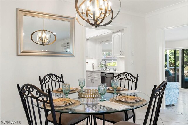 tiled dining room with ornamental molding, a notable chandelier, a healthy amount of sunlight, and sink